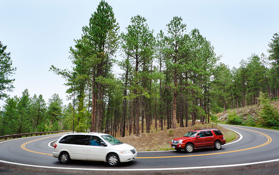 SUV and minivan driving on road