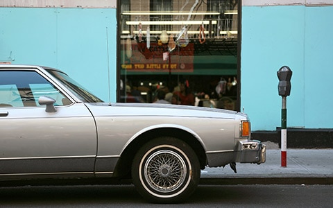 Older car parked in front of store