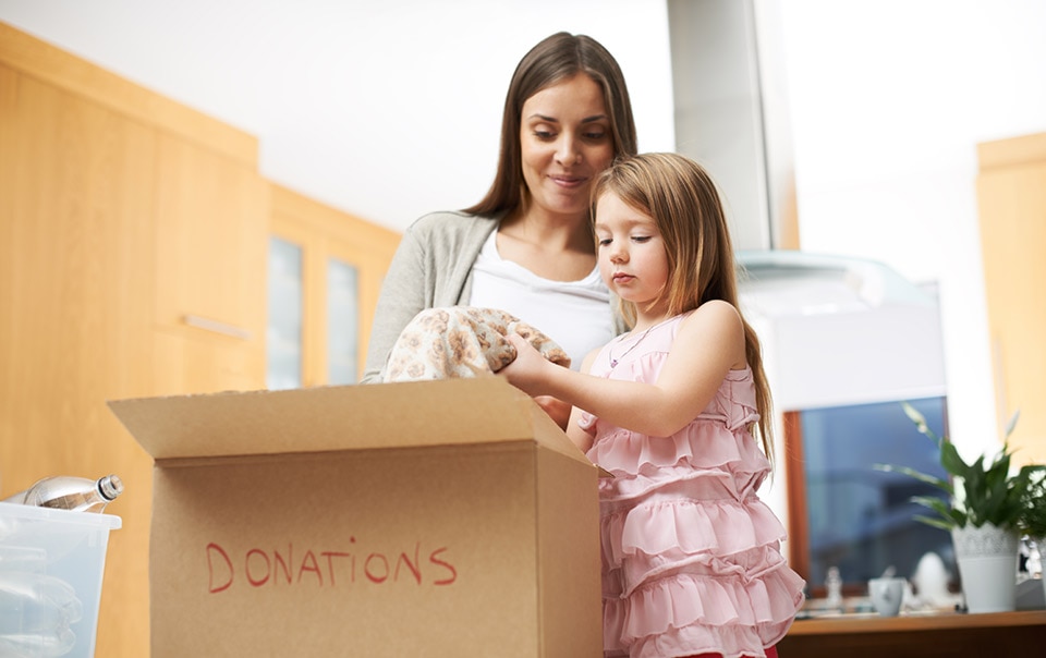 Woman declutter house by putting content in boxes with daughter