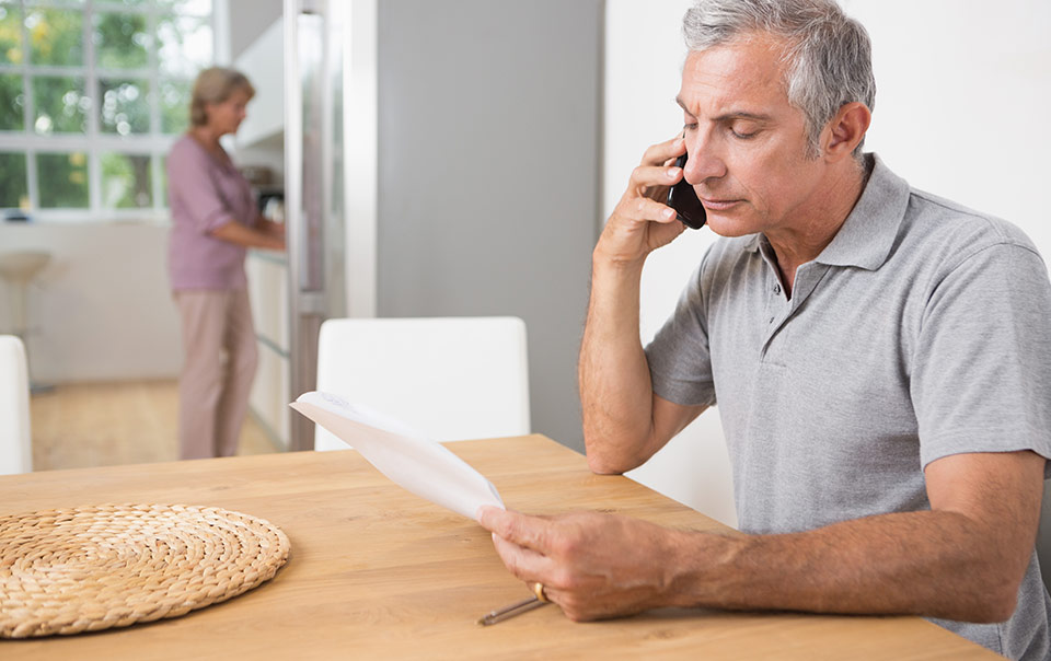 Male talking on phone with home insurance agent reporting a claim