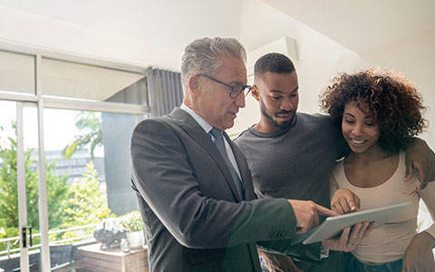 couple filling out home insurance papers with agent