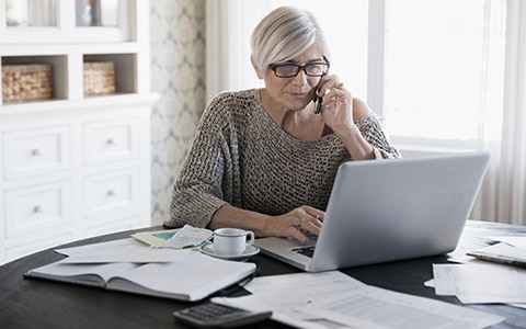 Woman getting a homeowners insurance quote over the phone in her home