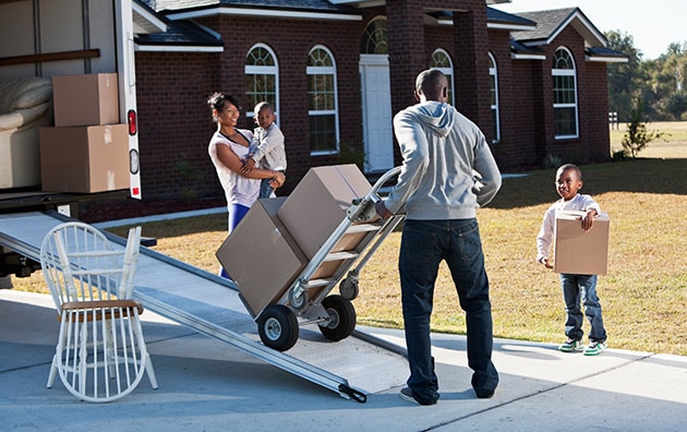 family moving boxes into moving truck