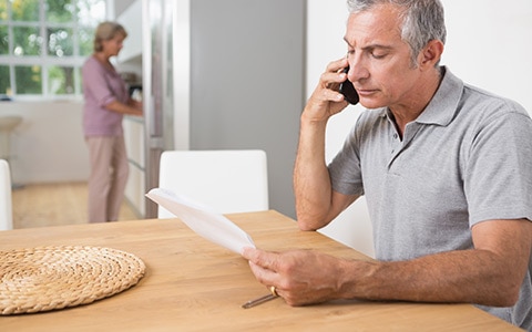 Man speaking on phone with agent about insurance claim process