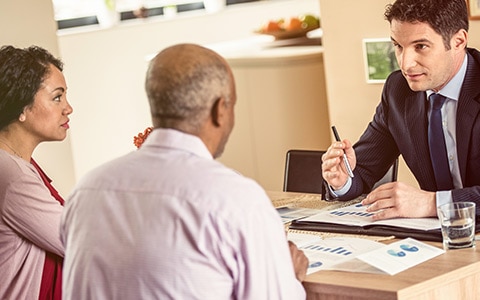 Couple talking with car insurance agent