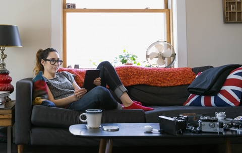 Female renter sitting on couch learning about renters insurance